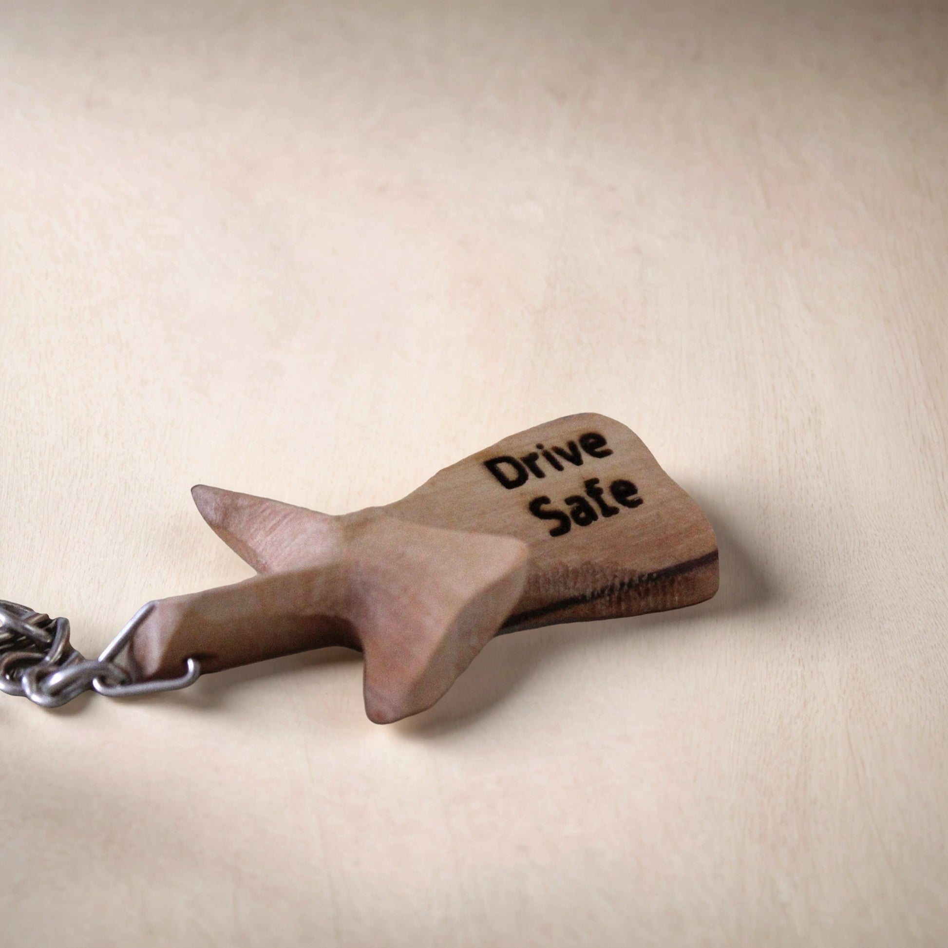 a wooden keychain with a drive safe message on it