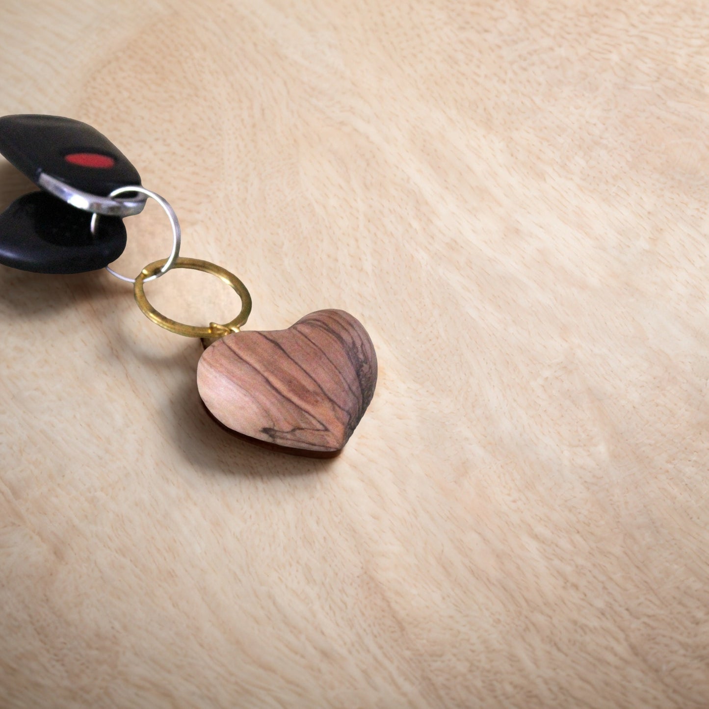 a wooden heart shaped keychain sitting on top of a wooden table