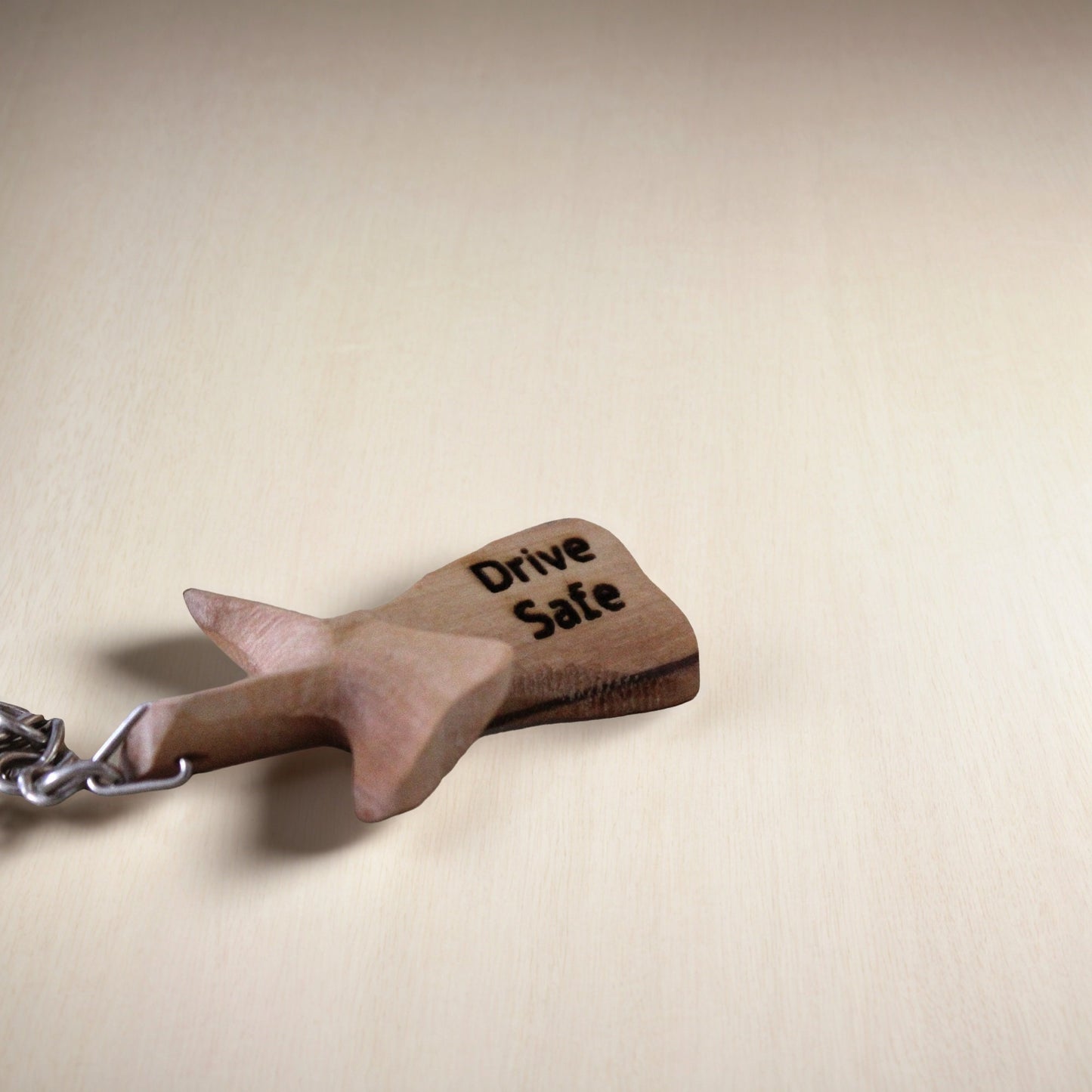 a wooden keychain with a drive safe message on it