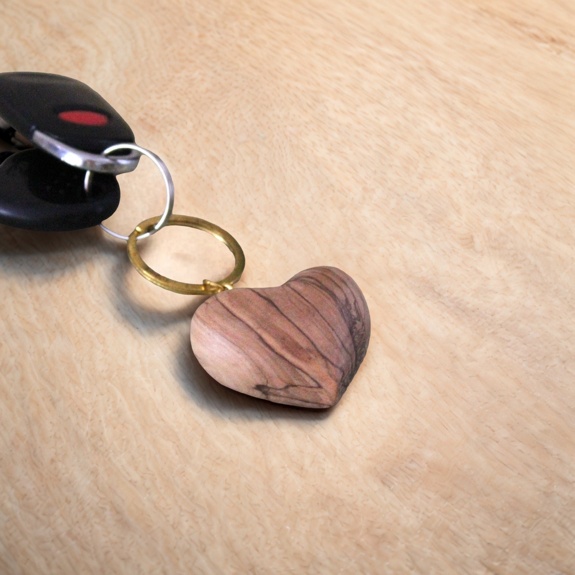 a wooden heart shaped keychain sitting on top of a wooden table